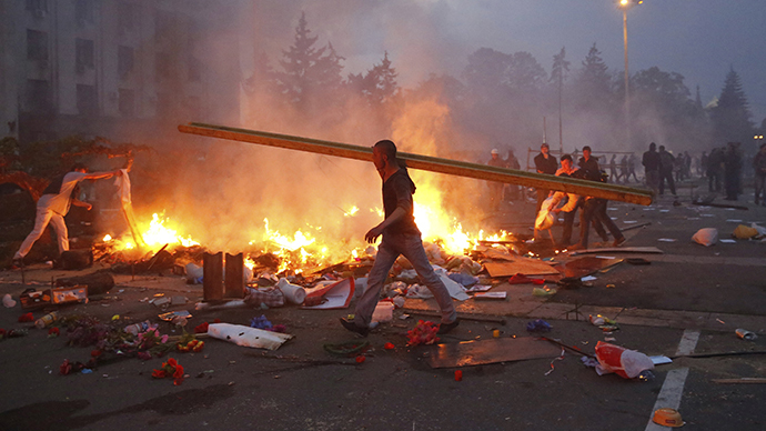 A pro-Kiev protester walks past a burning anti-Kiev tent camp near the Trade Union Building in Odessa May 2, 2014. (Reuters / Yevgeny Volokin)