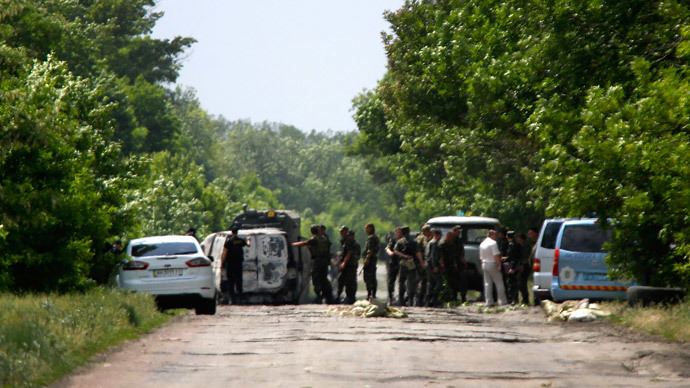 Ukrainian soldiers survey an area where Ukrainian servicemen were killed on the outskirts of the eastern Ukrainian town of Volnovakha, south of Donetsk May 22, 2014.(Reuters / Yannis Behrakis )