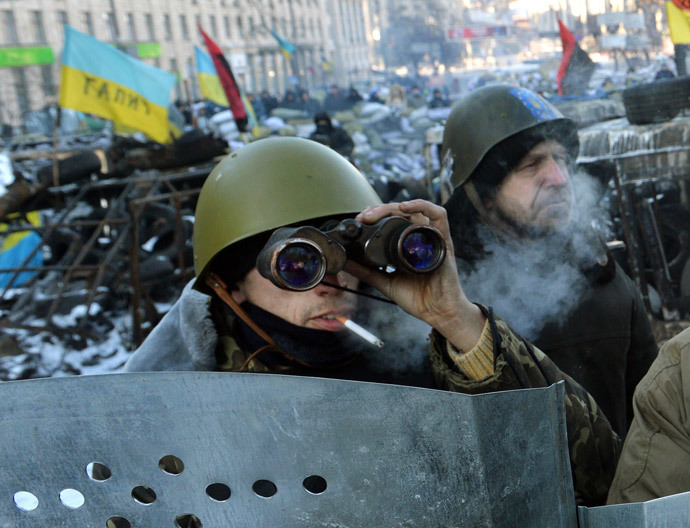 A man uses binoculars as protesters guard a road block in central Kiev on January 31, 2014. (AFP Photo / Sergei Supinski)