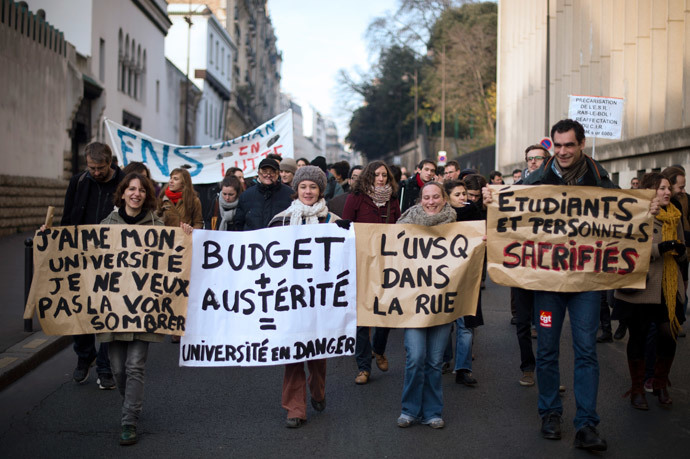 French protesters, including university students and researchers, hold banners as they rally against budget austerity in the education field. (AFP Photo / Lionel Bonaventure)