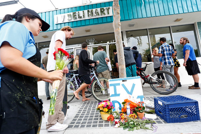 A woman places a flowers at a makeshift shrine outside a deli that was one of nine crime scenes after series of drive-by shootings that left 7 people dead in the Isla Vista section of Santa Barbara May 24, 2014. (Reuters / Jonathan Alcorn)