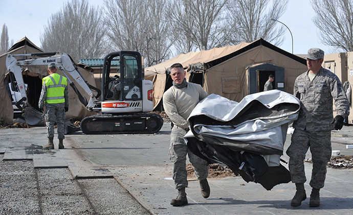 US servicemen carry a tent as they dismantle the tent camp at the US transit center in Manas, 30 kilometers outside Kyrgyzstan's capital Bishkek on March 6, 2014 (AFP Photo / Vyacheslav Oseledko)