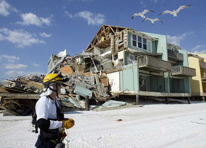 Juan Baquero of Central Florida Urban Search and Rescue Task Force 4 stands in front of a building, which was damaged by Hurricane Ivan, in Naverre Beach, Florida in this September 17, 2004, file photo (Reuters / Rick Wilking)