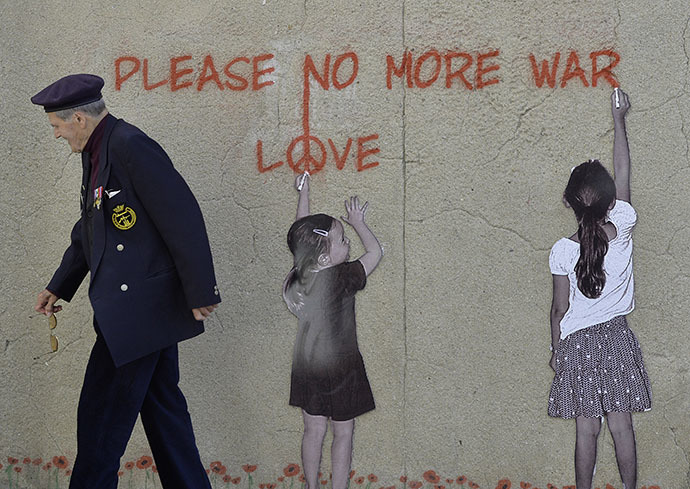 : An 88-year old British D-Day veteran Paul Butler passes along a wall mural at Arromanches-les-Bains on the Normandy coast with a graffiti saying âPlease, no more warâ (Reuters / Toby Melville)