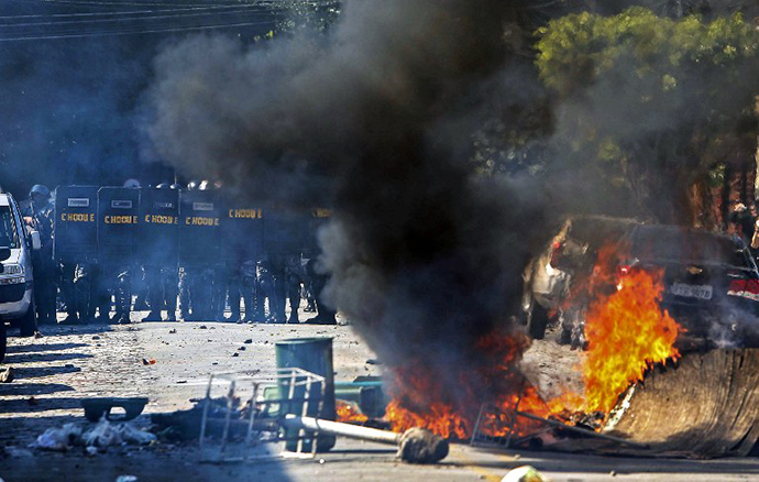 Riot policemen stand in position during an anti-World Cup protest on the morning the Brazilian mega-city hosts the tournament's opening match, in Sao Paulo on June 12, 2014. (AFP Photo / Miguel Schincariol)
