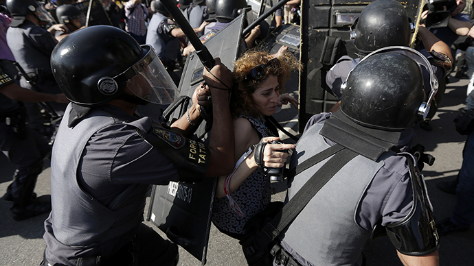 A woman is pushed by riot policemen during a clash with demontrators in a protest against the 2014 World Cup in Sao Paulo June 12, 2014. (Reuters / Ricardo Moraes)