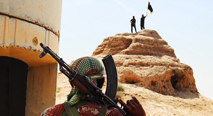 Militants of the Islamic State of Iraq and the Levant (ISIL) waving the trademark Islamists flag after they allegedly seized an Iraqi army checkpoint in the northern Iraqi province of Salahuddin on June 11, 2014. (AFP Photo / HO / Welyat Salahuddin)