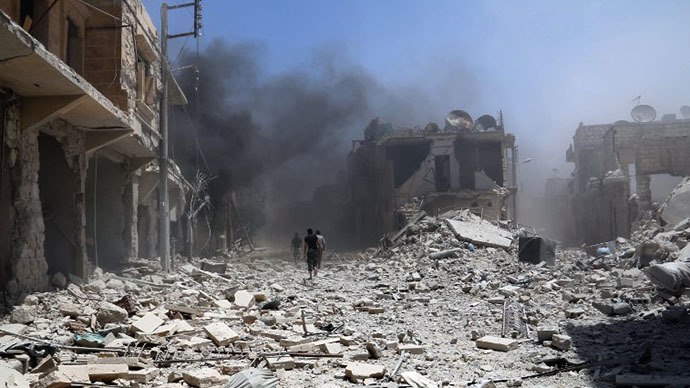 Rubble covers the street following an alleged airstrike by a Syrian army helicopter in the northern city of Aleppo, on June 11, 2014. (AFP Photo / Zein al-Rifai)