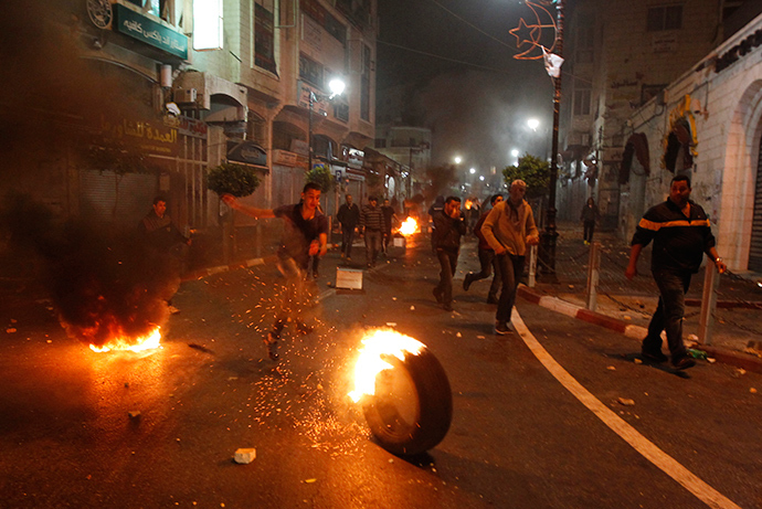 Palestinians set fire on tires during clashes with Israeli security forces taking part in the search for three missing teenagers early on June 22, 2014 in the West Bank city of Ramallah (AFP Photo / Abbas Momani)