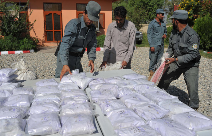 Afghan policemen count bags containing heroin as they are presented to the media at a police station in Jalalabad (AFP Photo / Noorullah Shirzada)