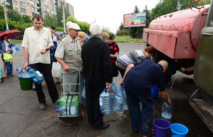 Residents queue up for water in front of a water truck in Kramatorsk, some 25 km south of Slavyansk on June 25, 2014. (AFP Photo / John Macdougall)