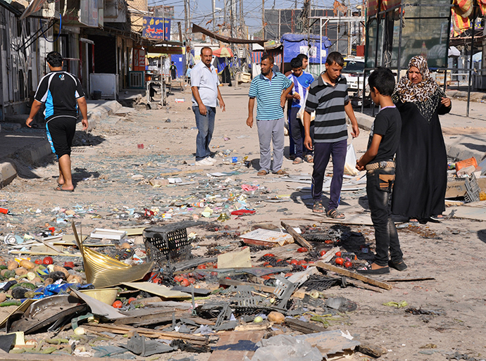 Residents look at the site of a suicide bomber attack in Mahmoudiya, south of Baghdad June 26, 2014 (Reuters / Ibrahim Sultan)