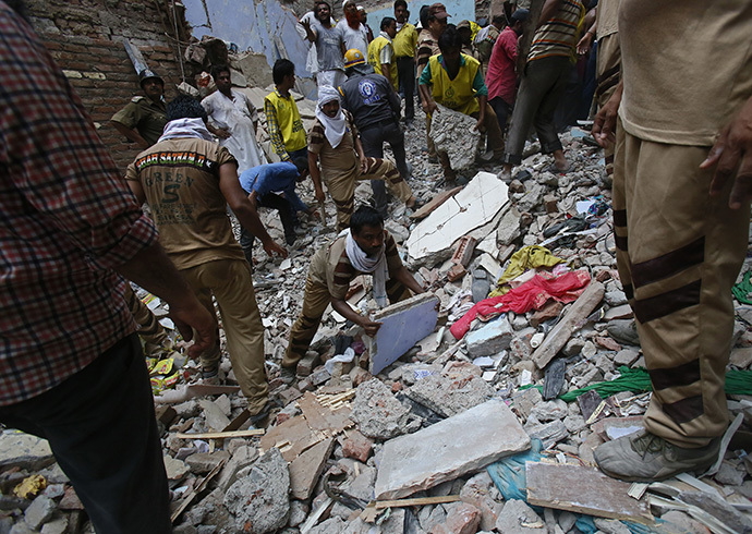 Rescue workers clear the debris from the site of a collapsed building in New Delhi June 28, 2014. (Reuters / Anindito Mukherjee)