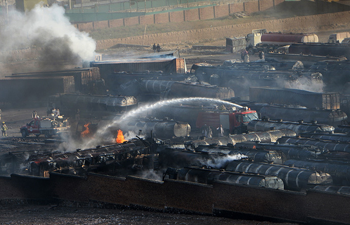 Afghan firefighters attempt to extinguish burning fuel trucks following an overnight attack by Taliban militants in Chawk-e-Arghandi on outskirts of Kabul on July 5, 2014. (AFP Photo / Wakil Kohsar)
