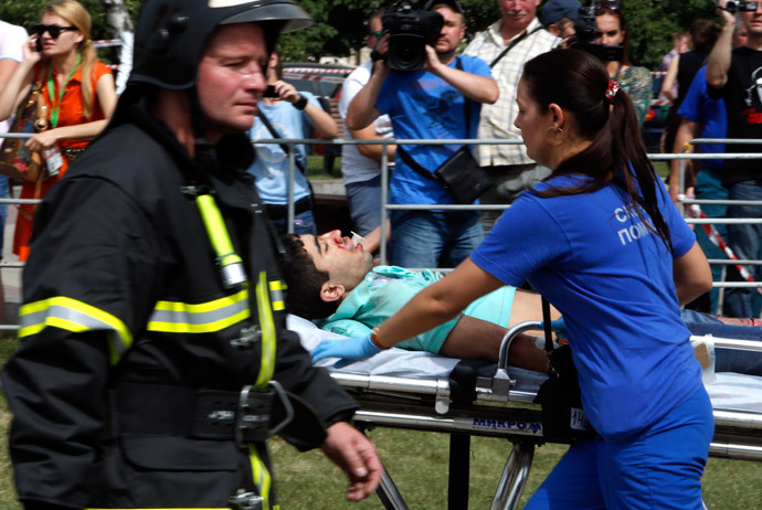 Members of the emergency services attend to an injured passenger outside a metro station following an accident on the subway in Moscow July 15, 2014. (Reuters / Sergei Karpukhin)