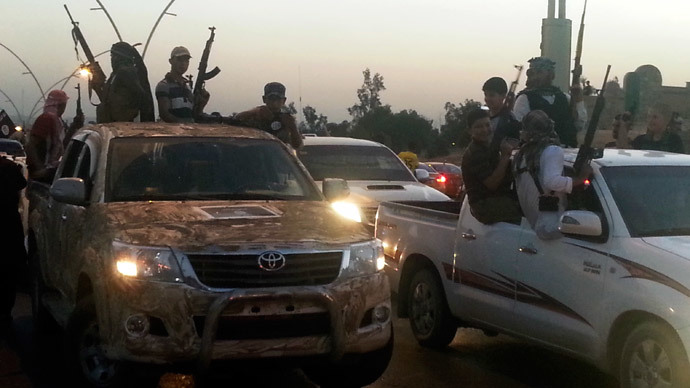 Fighters of the Islamic State of Iraq and the Levant (ISIL) celebrate while sitting on vehicles in the city of Mosul, June 23, 2014. (Reuters / Stringer)