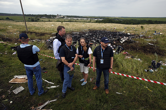 Organisation for Security and Cooperation in Europe (OSCE) monitors stand at the site of Thursday's Malaysia Airlines Boeing 777 plane crash near the settlement of Grabovo in the Donetsk region July 18, 2014. (Reuters / Maxim Zmeyev)