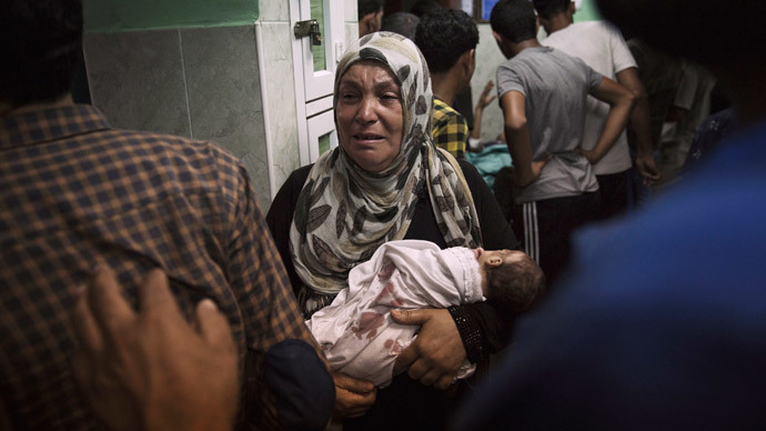 A Palestinian woman holds an infant, whom medics said was injured in an Israeli shelling at a U.N-run school sheltering Palestinian refugees, at a hospital in the northern Gaza Strip July 24, 2014.(Reuters / Finbarr O'Reilly)