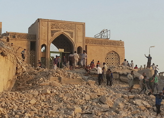 People walk through the rubble of the Prophet Younis Mosque after it was destroyed in a bomb attack by militants of the Islamic State, formerly known as the Islamic State in Iraq and the Levant (ISIL), in the city of Mosul, July 24, 2014. (Reuters)