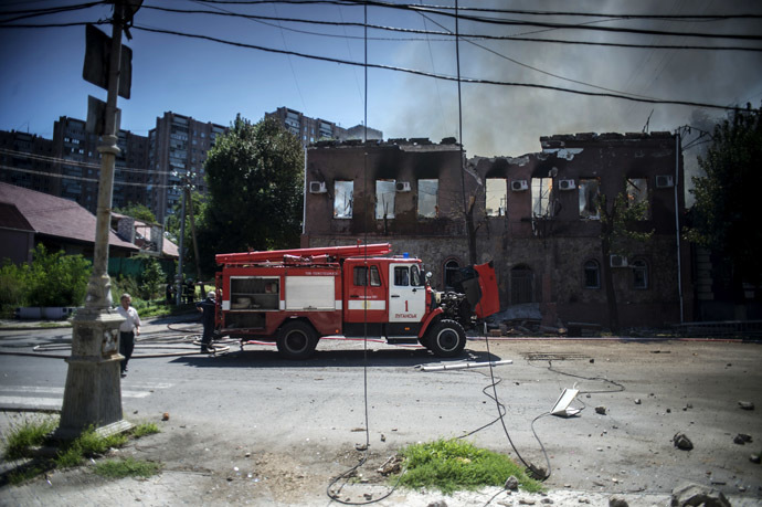 Fire brigade members extinguishing fire in a building hit by a shell during an artillery attack by the Ukrainian Security Forces in Lugansk. (RIA Novosti/Valeriy Melnikov)