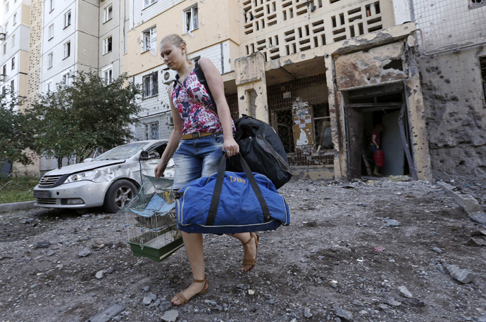 A woman walks out of a damaged multi-storey block of flats carrying her belongings following what locals say was recent shelling by Ukrainian forces in central Donetsk, July 29, 2014. (Reuters/Sergei Karpukhin)