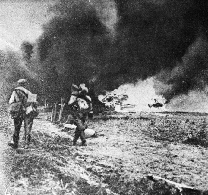 Soldiers leave burning village. Russian army retreat from Galicia. 1915. WWI of 1914-1918. Photo reproduction. (RIA Novosti / M. Filimonov)