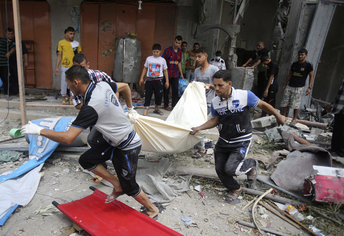 Palestinians carry the dead body of a woman after removing it from under the rubble of a house which witnesses said was destroyed in an Israeli air strike, in Rafah in the southern Gaza Strip August 4, 2014. (Reuters / Ibraheem Abu Mustafa)