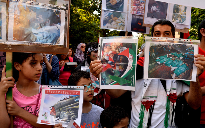 People hold up pictures during a demonstration in central Rome to protest against Israel's military campaign in Gaza. (AFP Photo / Tiziana Fabi)