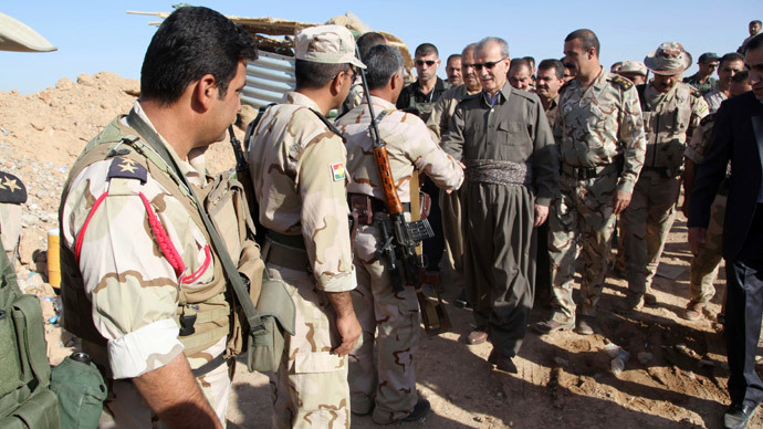 Kirkuk provincial Governor Najm al-Din Karim (C) shakes hands with Kurdish peshmerga forces in the district of Daquq.(AFP Photo / Marwan Ibrahim)