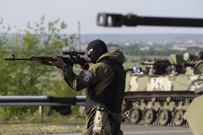 A Ukrainian soldier points his weapon at an approaching car with armoured personnel carriers behind him at a checkpoint near the town of Slaviansk in eastern Ukraine May 3, 2014. (Reuters/Baz Ratner)