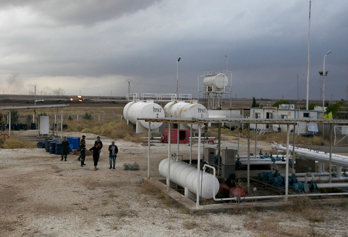 Members of the Kurdish People's Protection Units (YPG) stand near an oil refinery site (Reuters / Stringer)