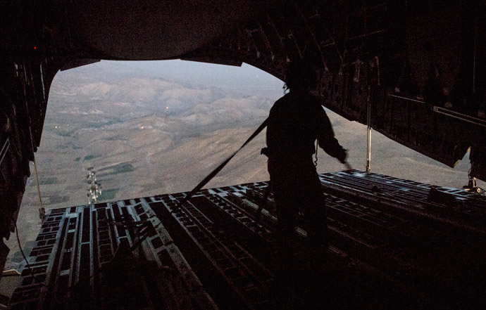 Tech. Sgt. Lynn Morelly, 816th Expeditionary Airlift Squadron, C-17 Globemaster III loadmaster, watches bundles of halal meals parachute to the ground during a humanitarian airdrop mission over Iraq in this August 9, 2014 photo (Reuters / Vernon Young Jr. / U.S. Air Force / Handout)