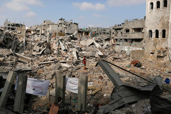 A boy stands amid the ruins of buildings that witnesses say were destroyed by Israeli air strikes in the Shejaia neighbourhood in Gaza City August 12, 2014. (Reuters / Siegfried Modola)