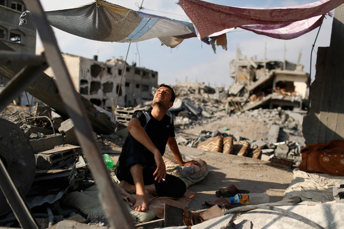 A man looks up as he sits in a tent amid the ruins of his home that he says was destroyed by Israeli air strikes in the Shejaia neighbourhood in Gaza City August 12, 2014. (Reuters / Siegfried Modola)