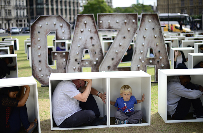 Volunteers sit in wooden boxes at Parliament Square, to represent living conditions in Gaza, during a protest in London August 14, 2014. (Reuters / Dylan Martinez)