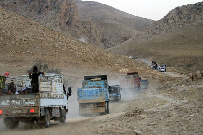 Displaced people from the Yazidi religious minority, fleeing violence from forces loyal to the Islamic State in Sinjar town, ride trucks as they are evacuated from Mount Sinjar in northern Iraq with the help of members of the Kurdish People's Protection Units (YPG), as they make their way towards Newrooz camp in Syria's al-Hasakah province, August 13, 2014. (Reuters / Rodi Said)