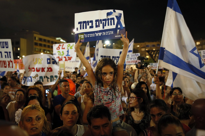 Israelis gather during a protest calling on the government and the army to end Palestinian rocket attacks from Gaza once and for all, in the Mediterranean city of Tel Aviv on August 14, 2014. Hebrew writting on placard reads "strong together." (AFP Photo / Gali Tibbon)