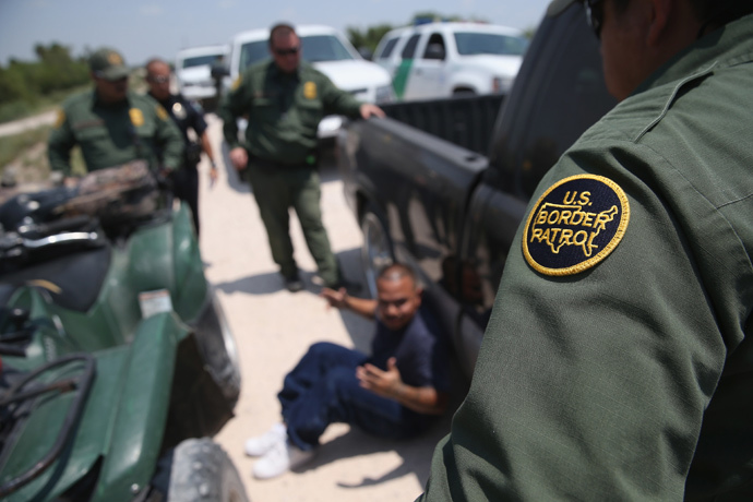 U.S. Border Patrol agents detain a suspected smuggler after he allegedly transported undocumented immigrants who crossed the Rio Grande from Mexico into the United States (John Moore / Getty Images / AFP)