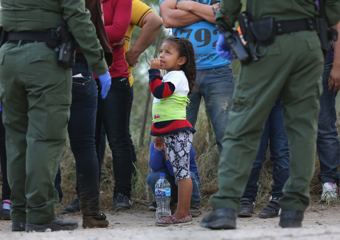 Central American immigrants await transportation to a U.S. Border Patrol processing center after crossing the Rio Grande from Mexico into the Texas (John Moore / Getty Images / AFP)