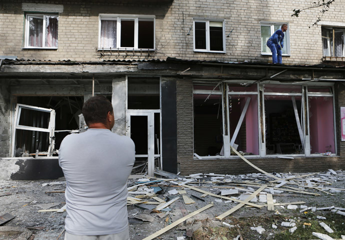 A local resident stands in front of an apartment block damaged by a recent shelling in the settlement of Makeyevka, on the outskirts of Donetsk, August 19, 2014. (Reuters/Maxim Shemetov)