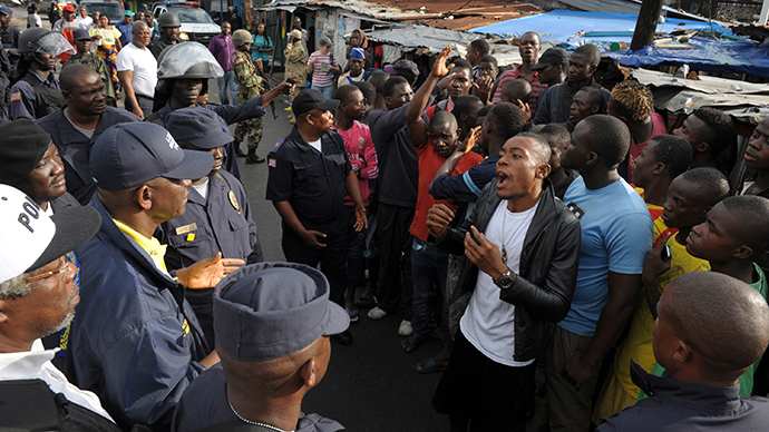 Members of Liberian security forces talk with a protester after clashes at West Point neighbourhood in Monrovia August 20, 2014 (Reuters / 2Tango)