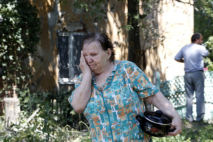 Local residents stand near buildings damaged during shelling on the outskirts of the eastern Ukrainian city of Donetsk August 3, 2014. (Reuters / Sergei Karpukhin)