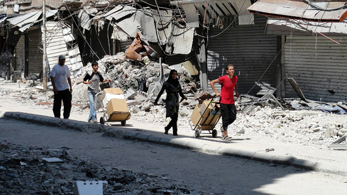 Residents of Syria's Yarmuk Palestinian refugee camp, south of Damascus, collect aid food on August 22, 2014. (AFP Photo / Rami Al-Sayed)