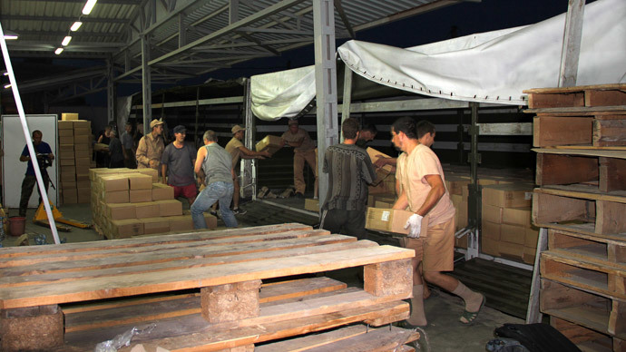 People download Russian humanitarian aid goods from a truck in Lugansk, on August 23, 2014.(AFP Photo / Stringer)