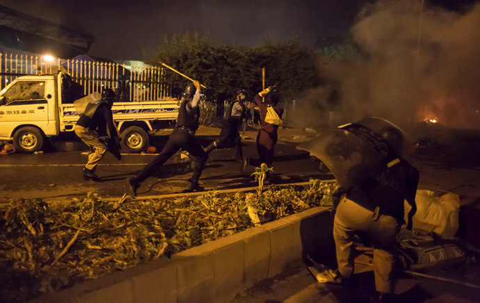 Riot police run after a supporter of Tahir ul-Qadri, Sufi cleric and leader of political party Pakistan Awami Tehreek (PAT), outside the parliament house as the supporters marched towards the prime minister's house in Islamabad August 30, 2014. (Reuters/Zohra Bensemra)