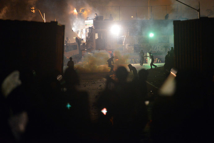 Supporters of cricketer-turned-politician Imran Khan and Canadian cleric Tahir ul Qadri throw stone toward the riot policemen following clashes with security forces near the prime minister's residence following clashes with security forces in Islamabad on August 31, 2014. (AFP Photo)
