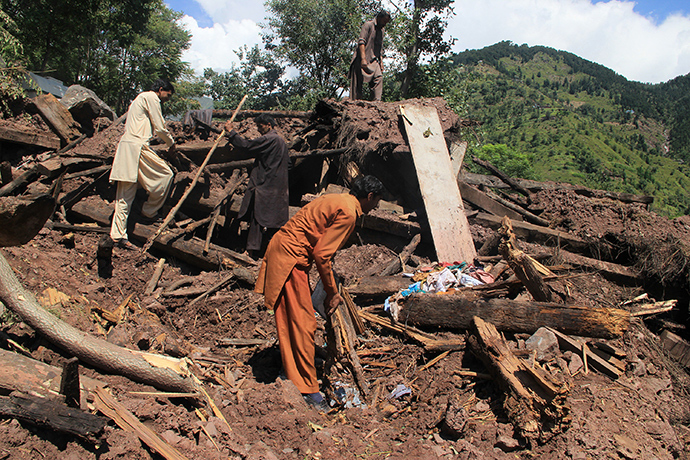 Pakistani Kashmiri people salvage belongings from the debris of their destroyed mud houses after landslides caused by heavy monsoon rain at Puna Bashan village, in district Haveli, some 150 kms from Muzaffarabad, the capital of Pakistan administrated Kashmir on September 9, 2014 (AFP Photo / Sajjad Qayyum)