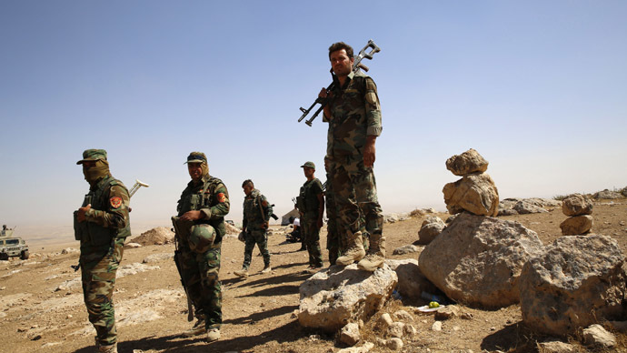 Kurdish Peshmerga fighters carry their weapons in an area overlooking Baretle village (not pictured) September 8, 2014. (Reuters/Ahmed Jadallah)