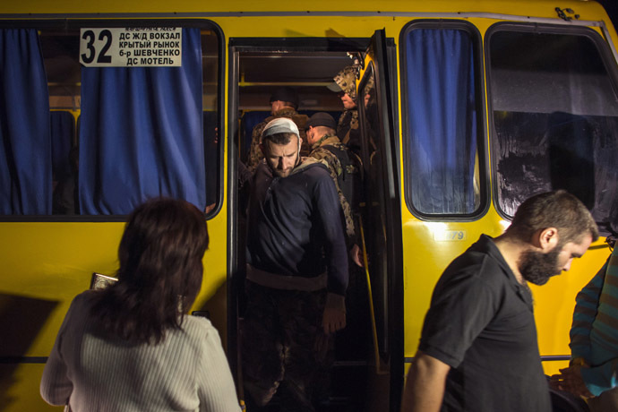 Members of the Ukrainian government forces, who are prisoners-of-war (POWs), exit a bus as they wait to be exchanged, north of Donetsk, eastern Ukraine, September 12, 2014. (Reuters/Marko Djuric)