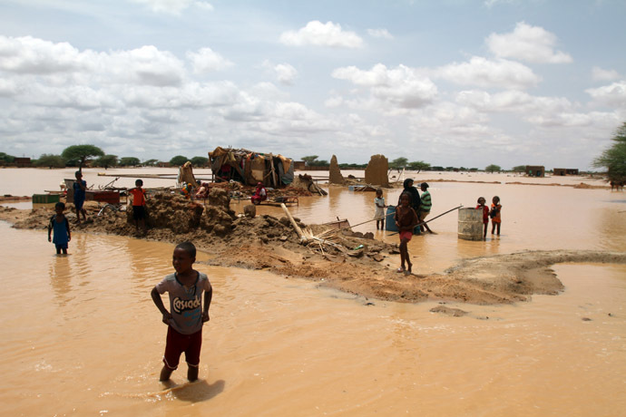 Sudanese children walks through a flooded street next to their home on the outskirts of the capital Khartoum on August 10, 2013. (AFP Photo)